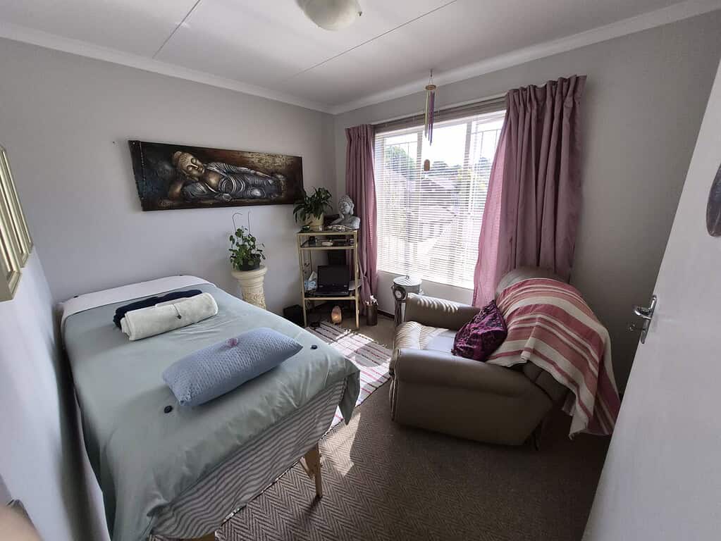 Comfortable therapy room with bed, armchair, and relaxing decor in Pretoria.