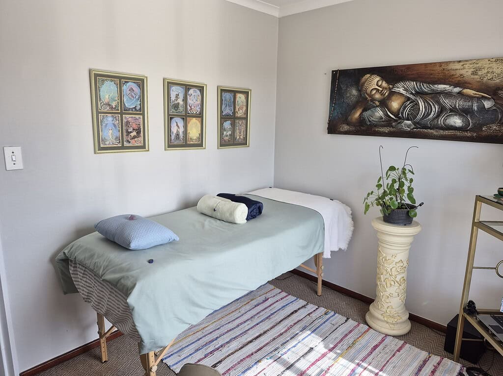 Relaxing therapy room with chakra artwork and massage table in Pretoria.